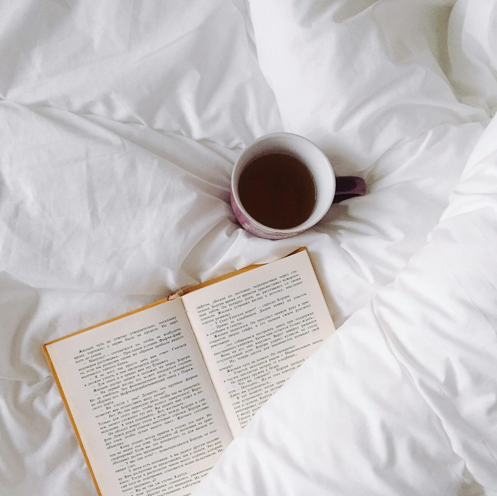 open book and coffee in bed